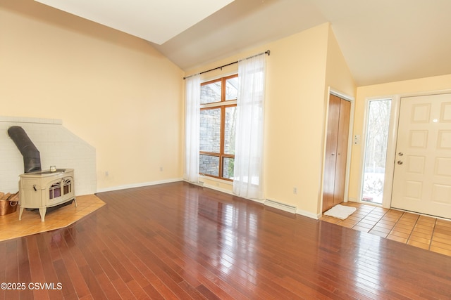 entryway with lofted ceiling, a wood stove, and hardwood / wood-style floors