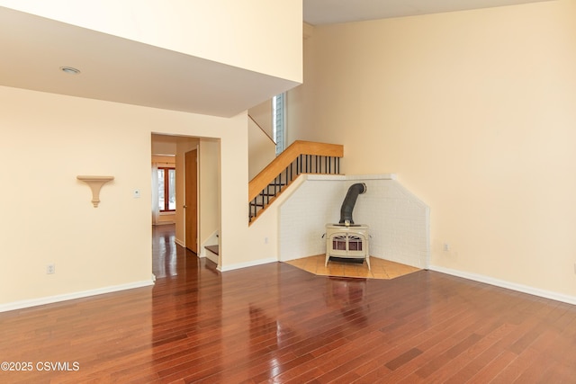 unfurnished living room with a wood stove and wood-type flooring