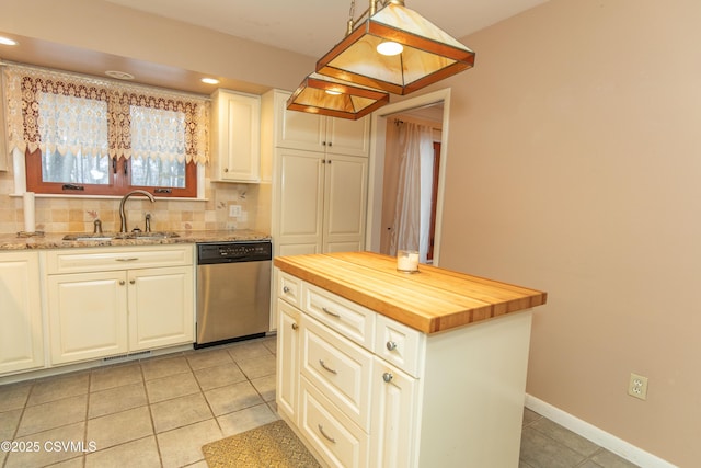 kitchen featuring decorative light fixtures, dishwasher, a kitchen island, sink, and wood counters