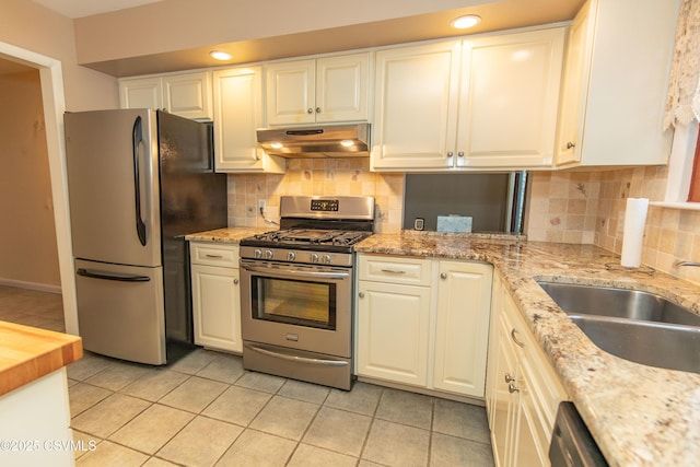 kitchen with light tile patterned floors, white cabinets, appliances with stainless steel finishes, and sink