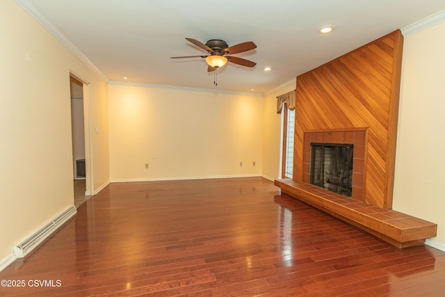 unfurnished living room with hardwood / wood-style floors, ceiling fan, baseboard heating, a fireplace, and crown molding