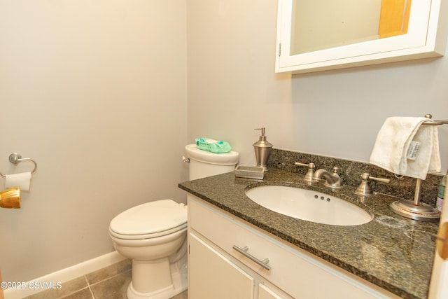 bathroom with toilet, vanity, and tile patterned flooring