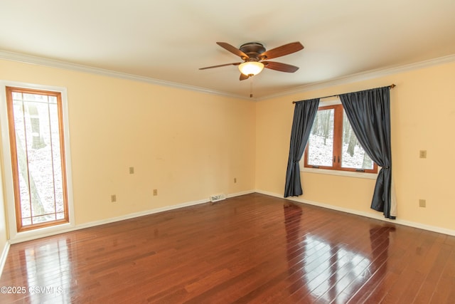 empty room with ceiling fan, a healthy amount of sunlight, ornamental molding, and hardwood / wood-style flooring