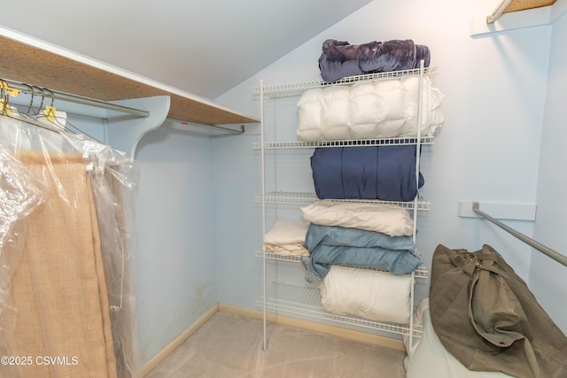 spacious closet with lofted ceiling and carpet floors