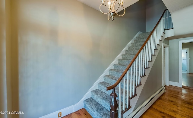 stairs featuring wood-type flooring and an inviting chandelier