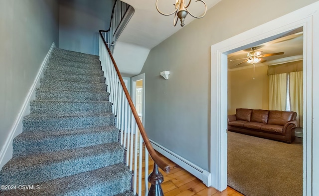 stairs featuring carpet, ceiling fan with notable chandelier, ornamental molding, and baseboard heating