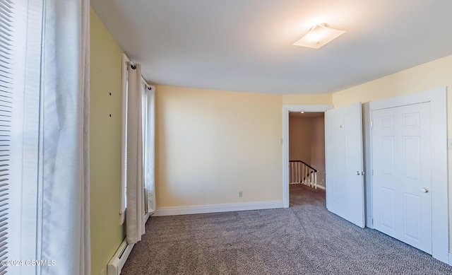 unfurnished bedroom with carpet and a baseboard radiator