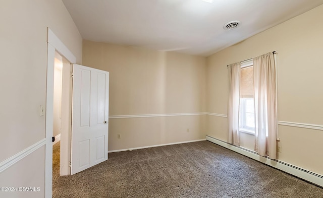 carpeted empty room with a baseboard heating unit