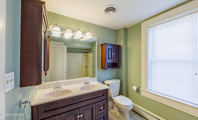 bathroom featuring tile patterned flooring, a healthy amount of sunlight, toilet, and a baseboard heating unit