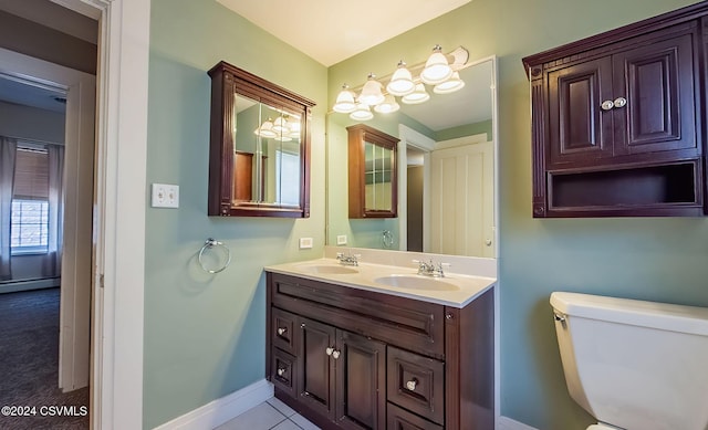 bathroom with tile patterned flooring, vanity, toilet, and a baseboard heating unit