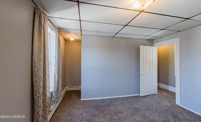 carpeted empty room with a drop ceiling and a baseboard radiator