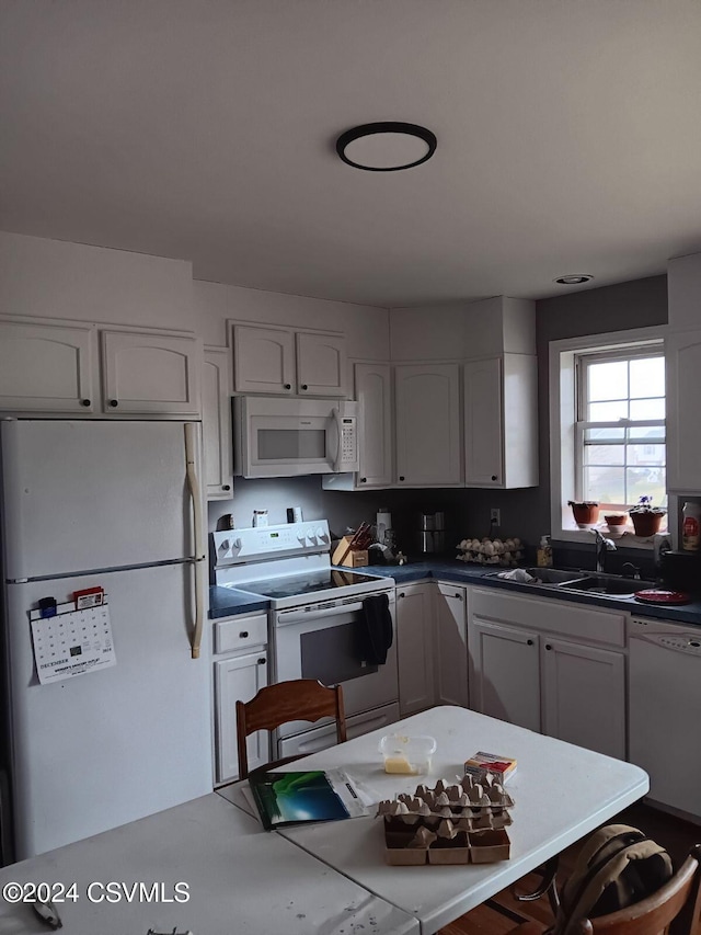 kitchen featuring white cabinets, white appliances, and sink