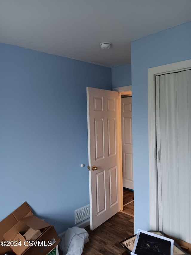 bedroom featuring dark hardwood / wood-style flooring and a closet