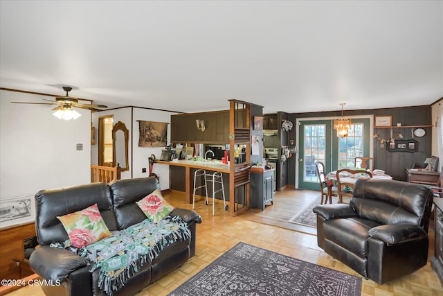 living room featuring light parquet flooring and ceiling fan with notable chandelier