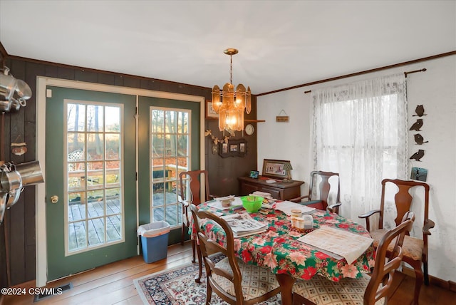 dining space with wood-type flooring and a notable chandelier