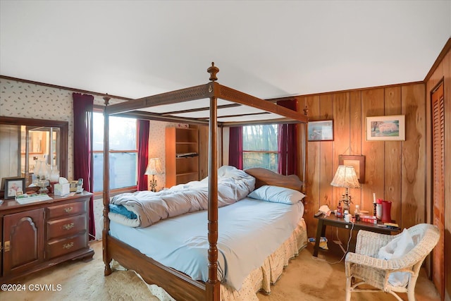 carpeted bedroom featuring ornamental molding and wooden walls