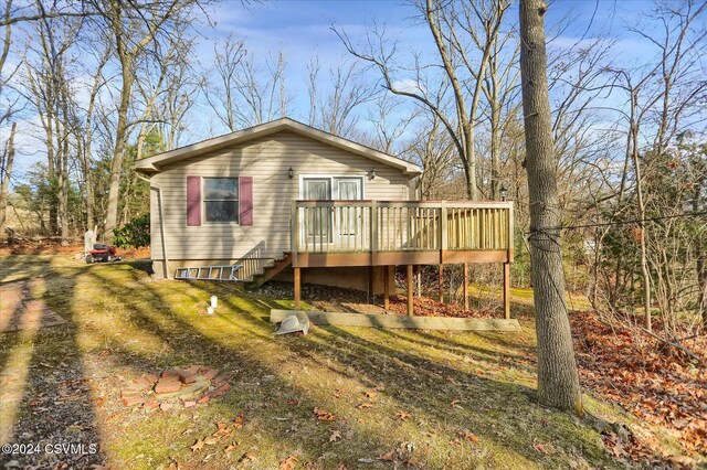 back of house with a lawn and a wooden deck