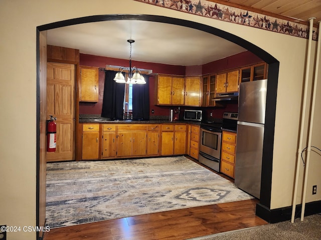 kitchen featuring sink, appliances with stainless steel finishes, decorative light fixtures, wood-type flooring, and a chandelier