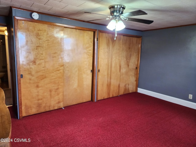 unfurnished bedroom with dark colored carpet and ceiling fan