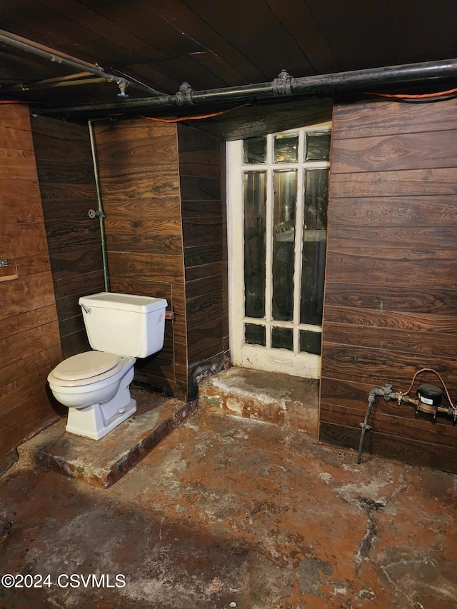 bathroom with toilet and wooden walls