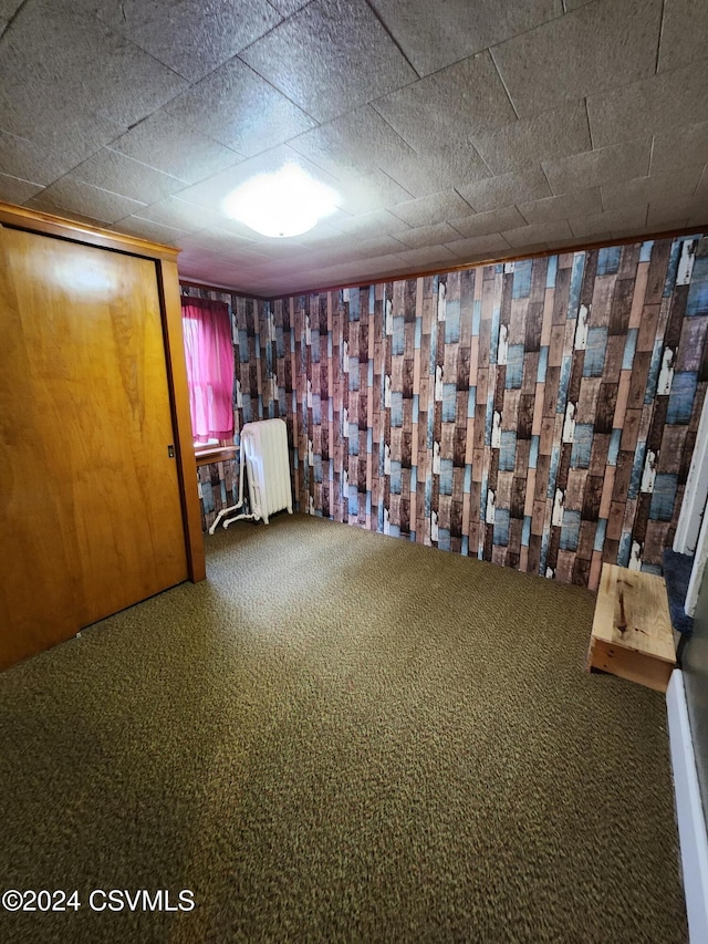 unfurnished bedroom featuring radiator heating unit and carpet floors