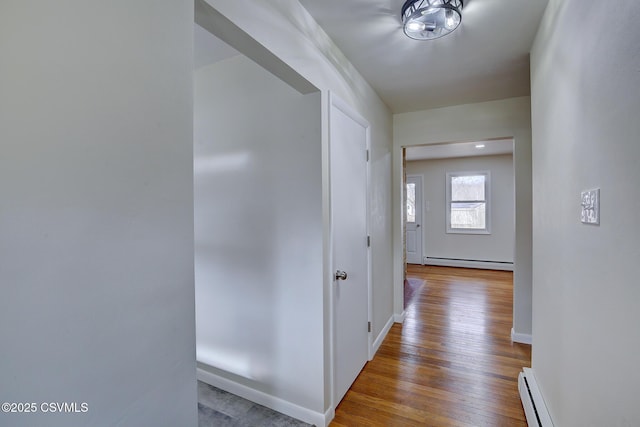 hall with light hardwood / wood-style floors and a baseboard heating unit