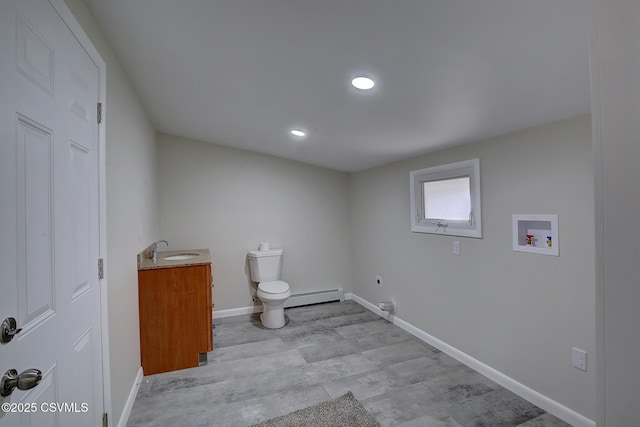 laundry area featuring sink, washer hookup, electric dryer hookup, a baseboard heating unit, and light hardwood / wood-style floors