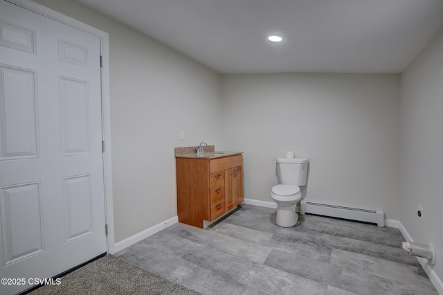 bathroom with vanity, toilet, and a baseboard heating unit