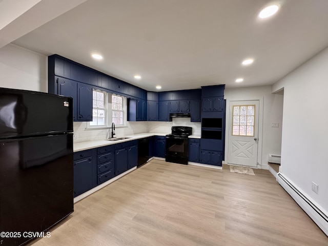 kitchen with sink, backsplash, baseboard heating, and black appliances