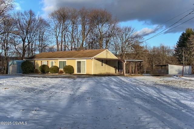 snow covered property featuring an outbuilding