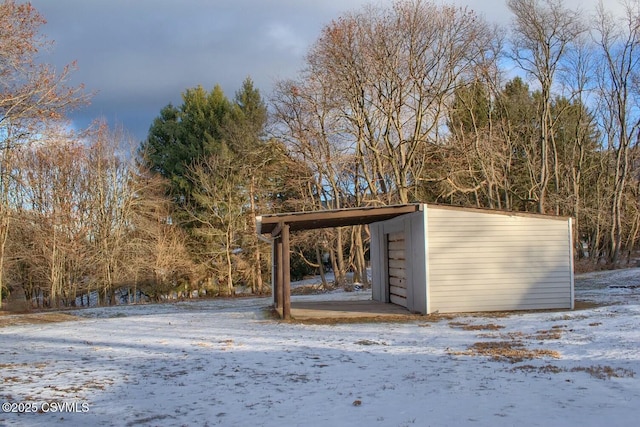 snow covered structure with a carport