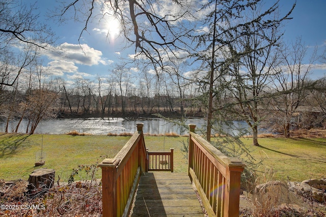 view of property's community with a water view and a lawn