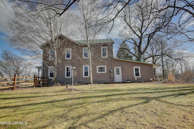 rear view of house featuring a lawn