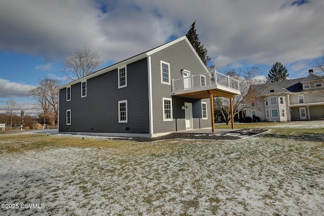 rear view of property featuring a wooden deck and a patio