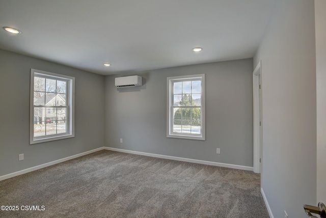 spare room with light colored carpet, an AC wall unit, and a healthy amount of sunlight