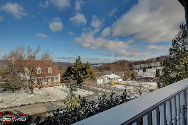 view of snow covered back of property