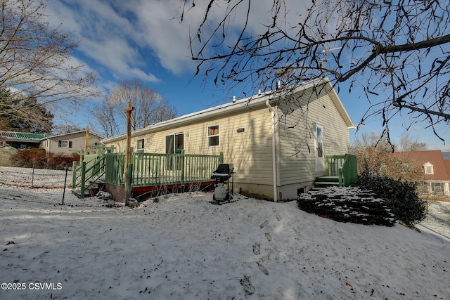 snow covered house featuring a deck