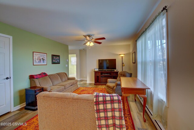 living room featuring light hardwood / wood-style floors, a baseboard radiator, and ceiling fan