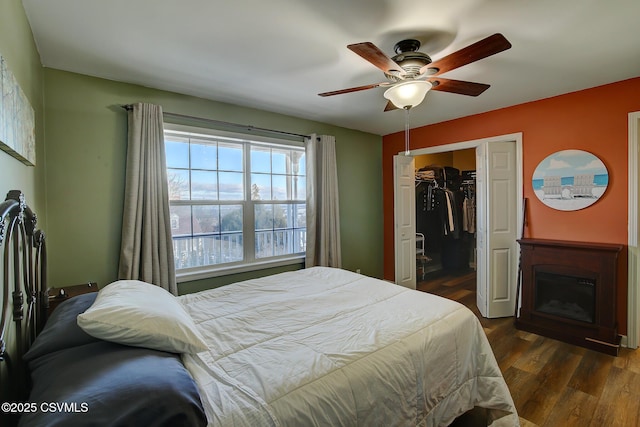 bedroom featuring ceiling fan, a closet, and dark wood-type flooring