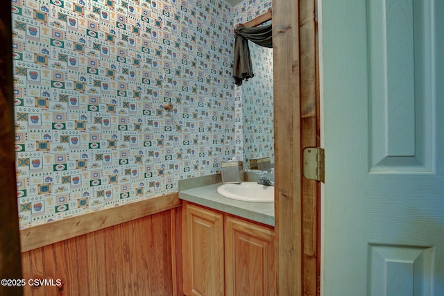 bathroom featuring wooden walls and vanity