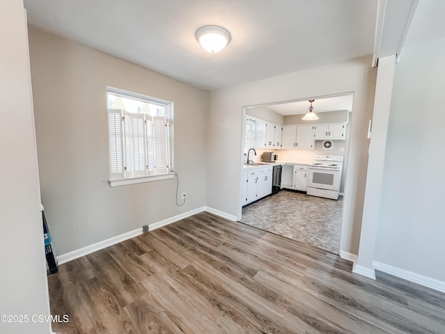 kitchen featuring dark wood-type flooring, sink, white electric stove, white cabinets, and black dishwasher