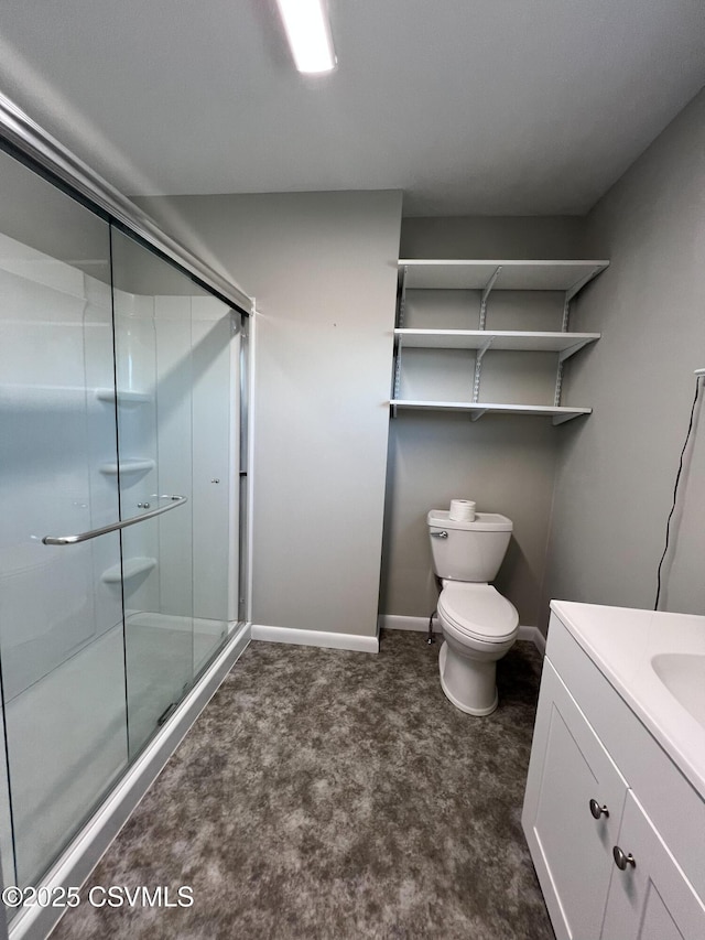 bathroom featuring vanity, toilet, and a shower with door