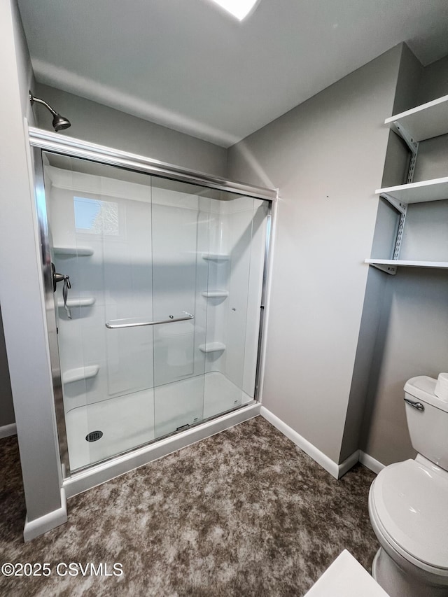 bathroom with a shower with shower door and toilet