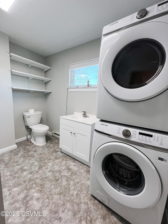 laundry room with baseboard heating, stacked washer and clothes dryer, and sink