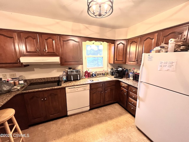 kitchen featuring a chandelier, sink, dark stone countertops, and black appliances