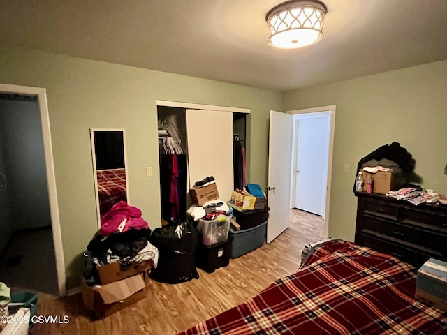 bedroom with light wood-type flooring and a closet