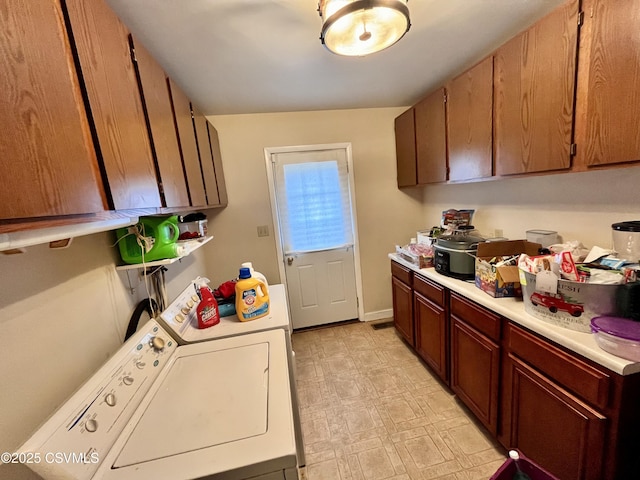 clothes washing area featuring washer and dryer and cabinets