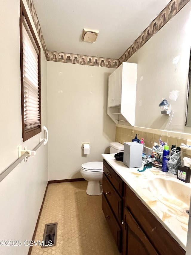 bathroom featuring decorative backsplash, toilet, and vanity