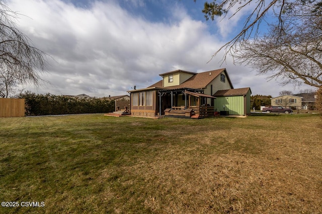 rear view of house with a sunroom and a yard