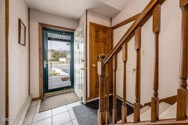 entrance foyer featuring a baseboard radiator, a textured ceiling, and light tile patterned floors